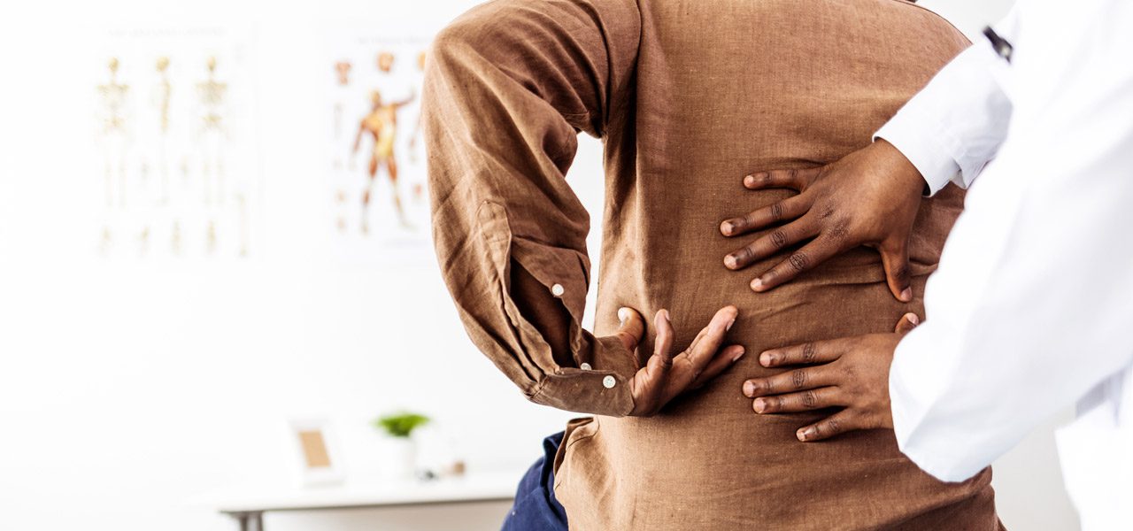 Doctor-examining-patient’s-back-before-sympathetic-ganglion-block-treatment