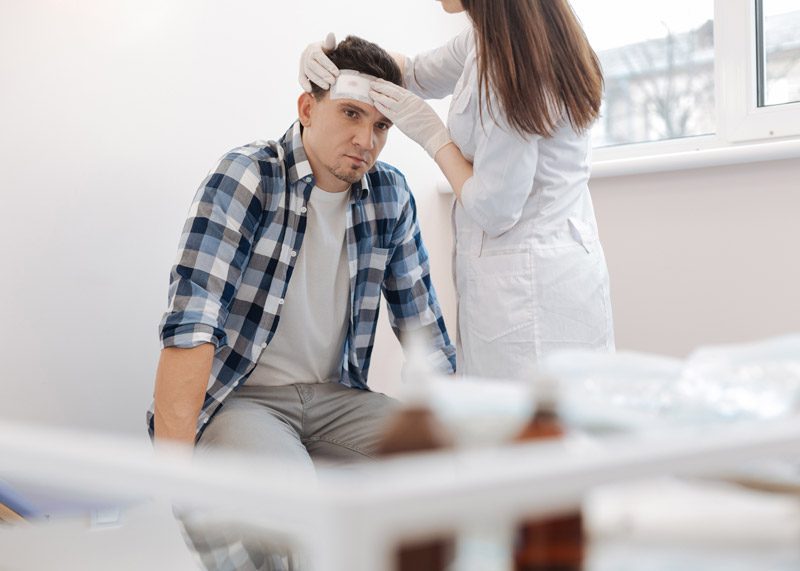 Male-patient-receiving-first-aid-for-traumatic-brain-injury